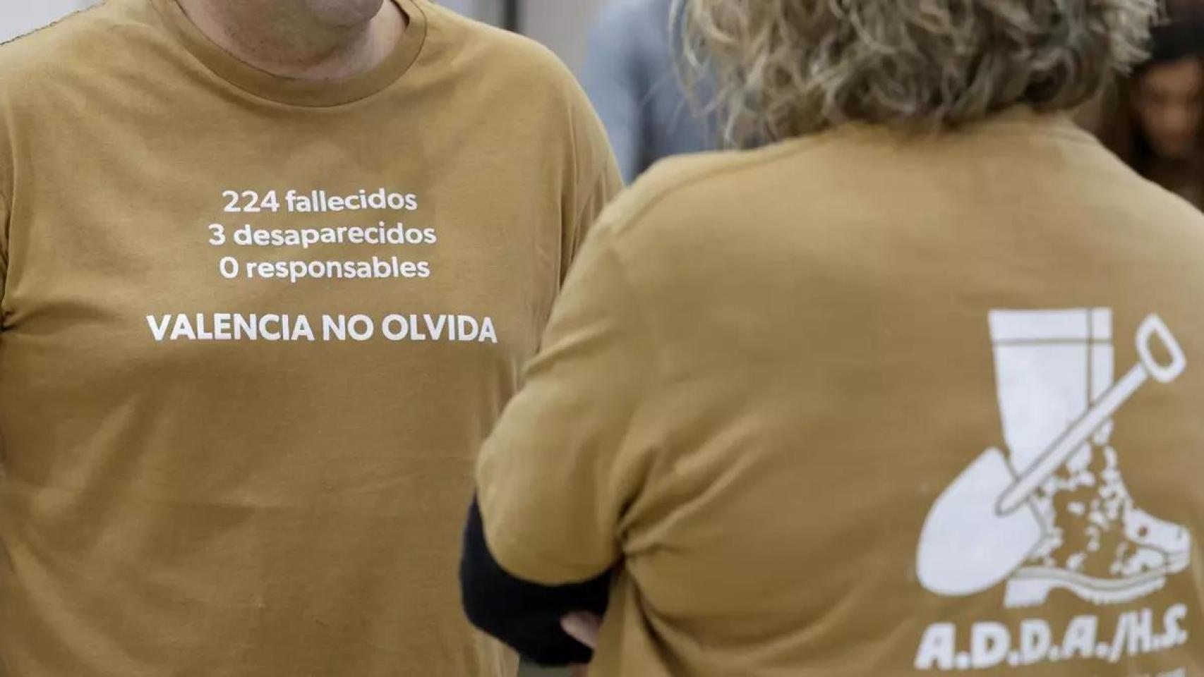 Dos personas vestidas con camisetas de la Asociación de Damnificados Horta Sud Valencia. EFE/Ana Escobar