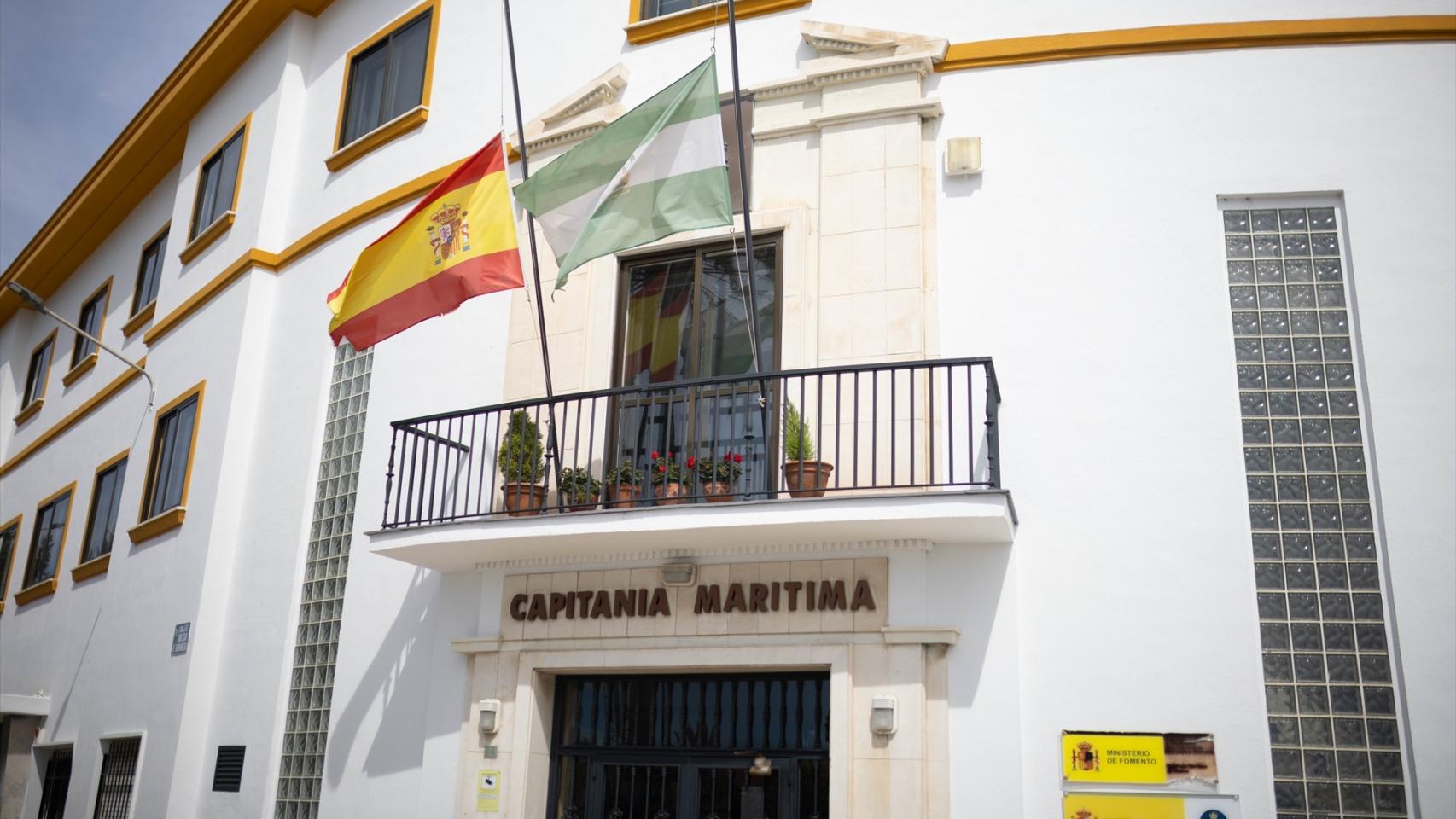 La fachada de la Capitanía Marítima de Huelva, este viernes, con las banderas de España y Andalucía a media asta.
