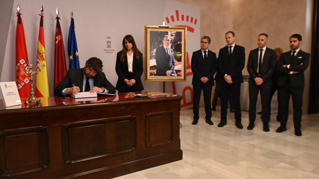 El presidente de la Región de Murcia, Fernando López Miras, este lunes, firmando en el libro de condolencias de José Ballesta, cuya capilla se ha habilitado en el Ayuntamiento de Murcia.