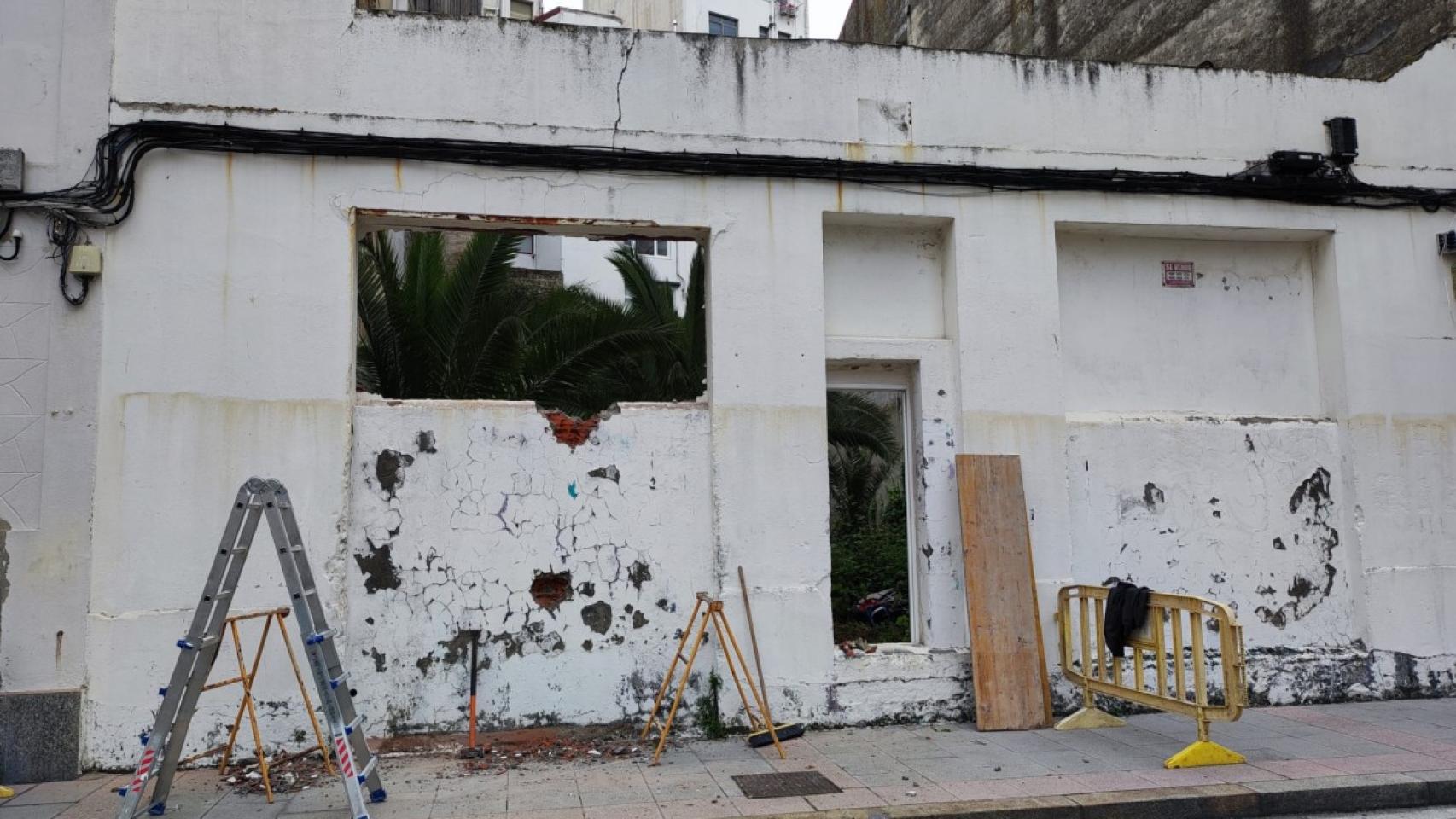 Espacio abierto en el solar tapiado de la calle Adelaida Muro, con vegetación en el interior.