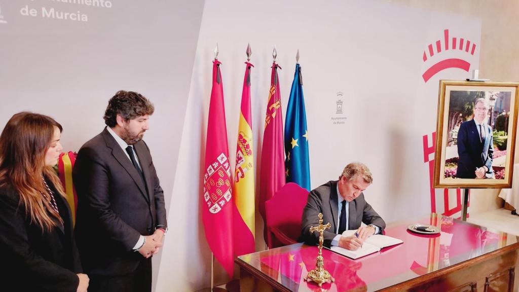 Rebeca Pérez, alcaldesa en funciones de Murcia, Fernando López Miras, jefe del Ejecutivo regional, y Alberto Núñez Feijóo, presidente del PP, este martes, firmando en el libro de condolencias de José Ballesta.