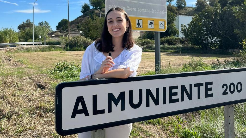 Carla Rivas posa junto al cartel de entrada a su pueblo, Almuniente, durante una de sus grabaciones.