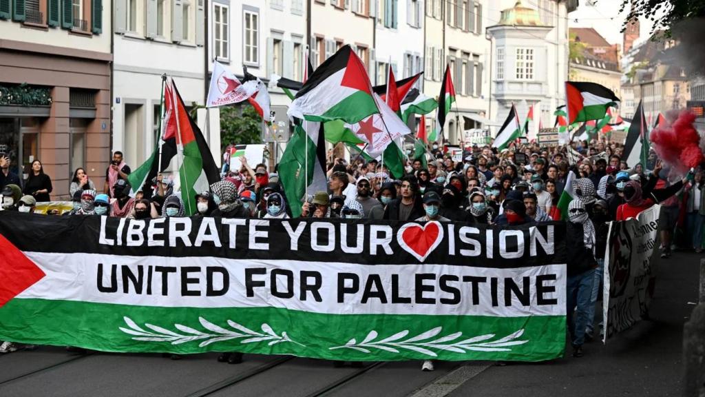 Manifestantes portan una pancarta y banderas palestinas durante una protesta contra el candidato israelí antes de la gran final del Festival de Eurovisión 2025 en Basilea, el 17 de mayo de 2025
