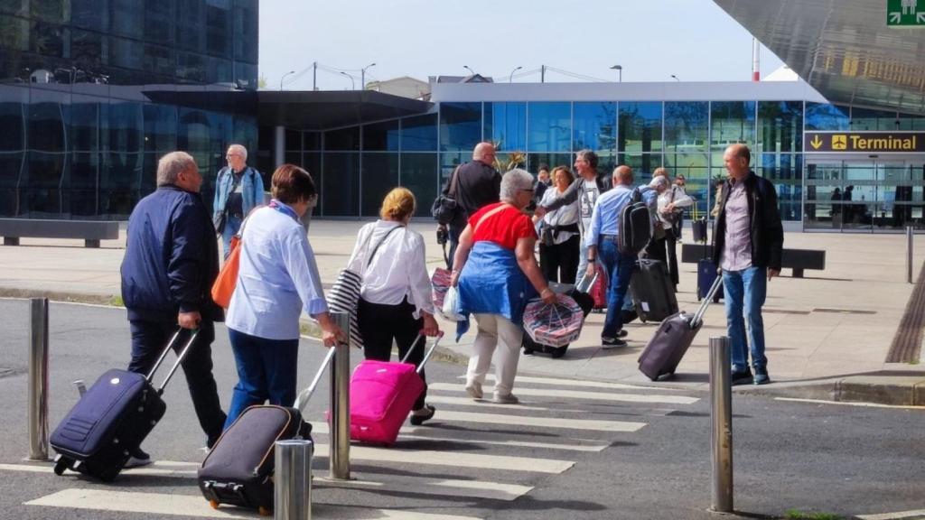 Pasajeros se dirigen a la terminal de Alvedro tras bajar de un autobús.