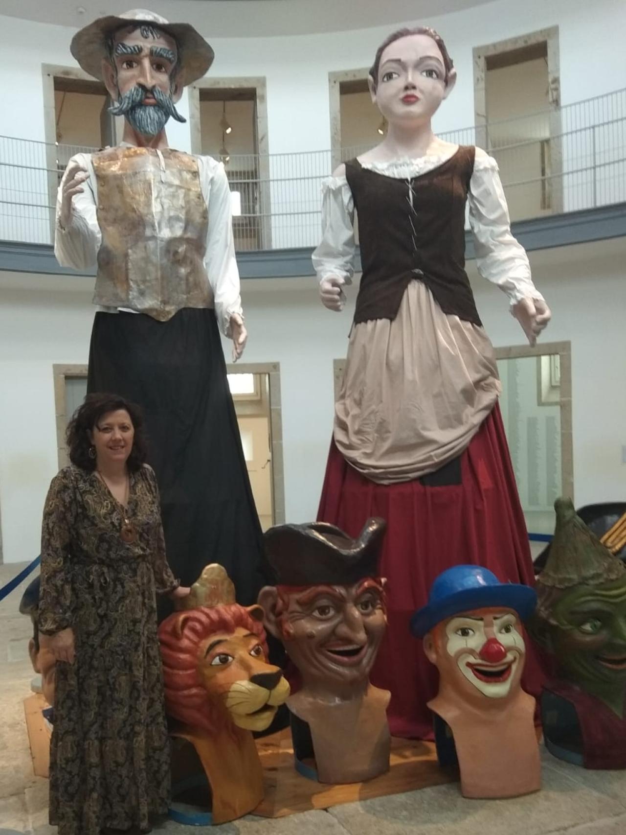 Marga Portomeñe con dos gigantes y varios cabezudos que ha restaurado.