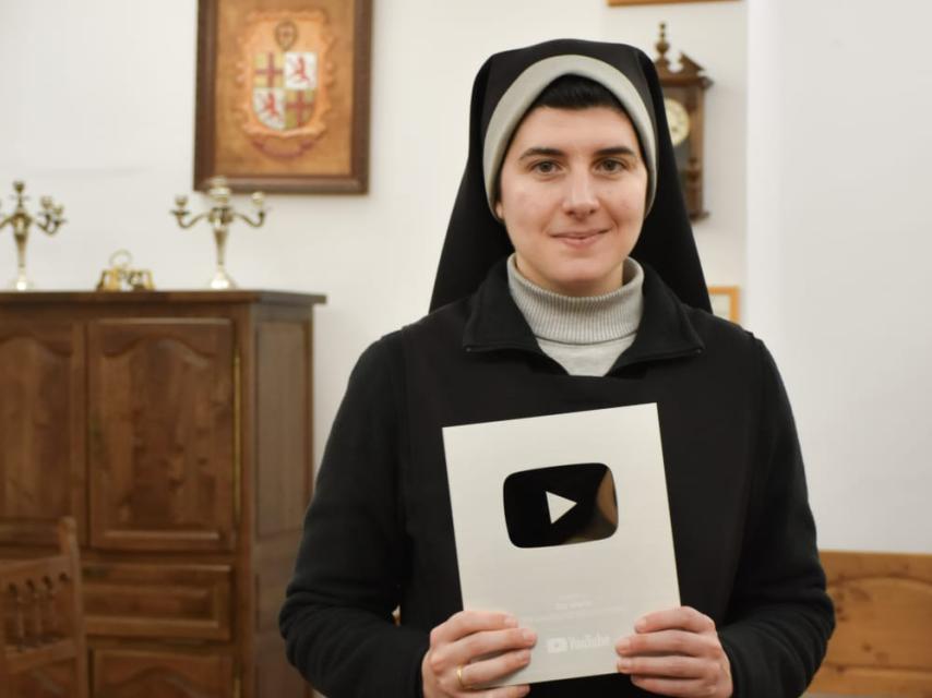 Sor Marta mostrando su placa de 100.000 suscriptores en YouTube.