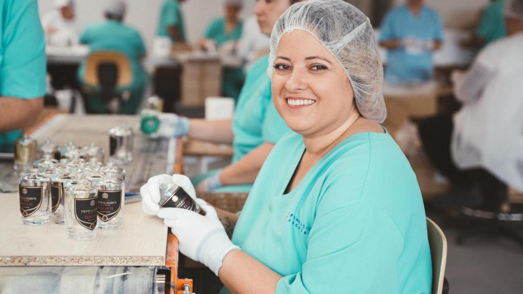 Ruth Azcona etiquetando frascos de perfume en la planta de la Fundación Arcoíris.