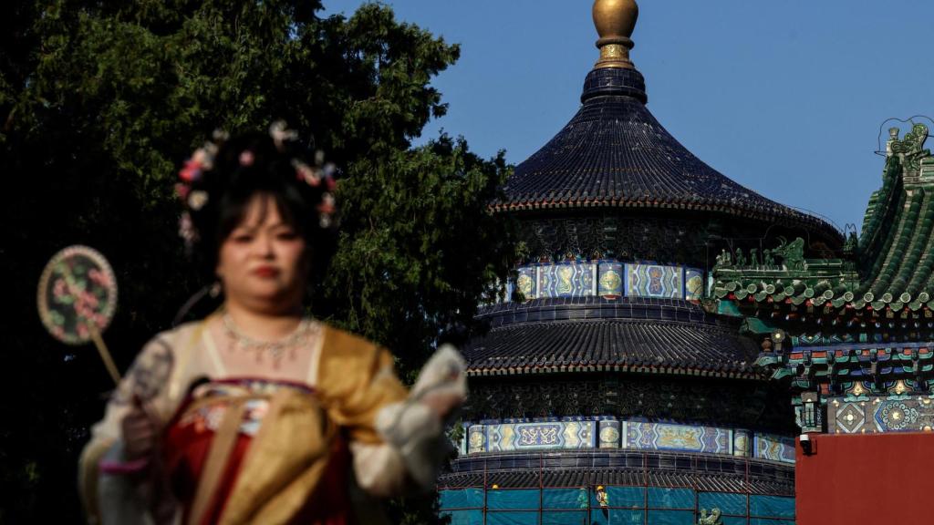 Una mujer con vestimenta tradicional en el complejo del Templo del Cielo.