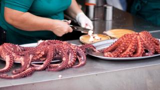 Una mujer prepara un plato de pulpo á feira