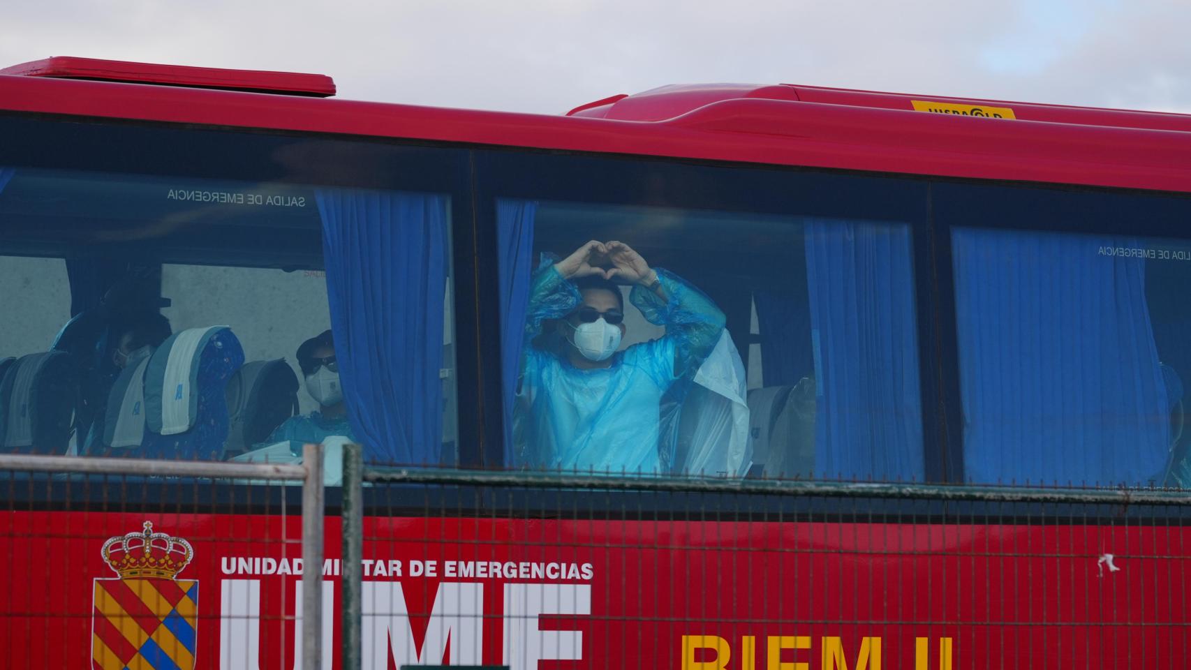 Pasajeros evacuados del crucero MV Hondius fondeado cerca del puerto de Granadilla suben a los autocares de la UME.