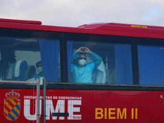 Pasajeros evacuados del crucero MV Hondius fondeado cerca del puerto de Granadilla suben a los autocares de la UME.