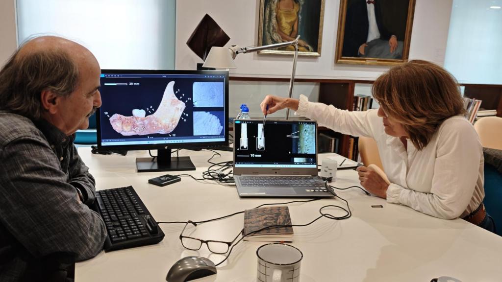 Jorge Soler y Consuelo Roca repasan las imágenes tomadas de los restos humanos encontrados en la Cova Randero.