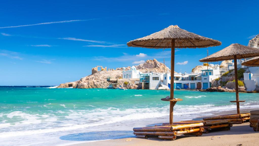 Playa en Milos con sombrillas y tumbonas.