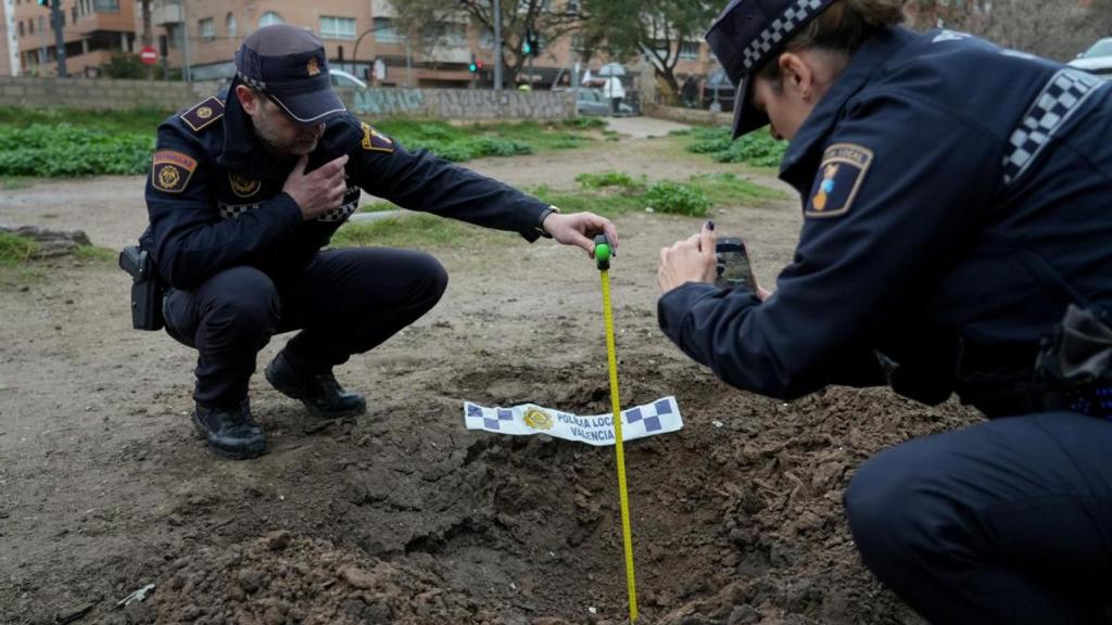 Agentes de la Policía Local junto al resultado de un petardo ilegal. PLV
