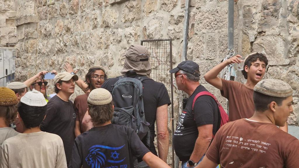 Jóvenes judíos acosan a un hombre con una camisa de Palestina.