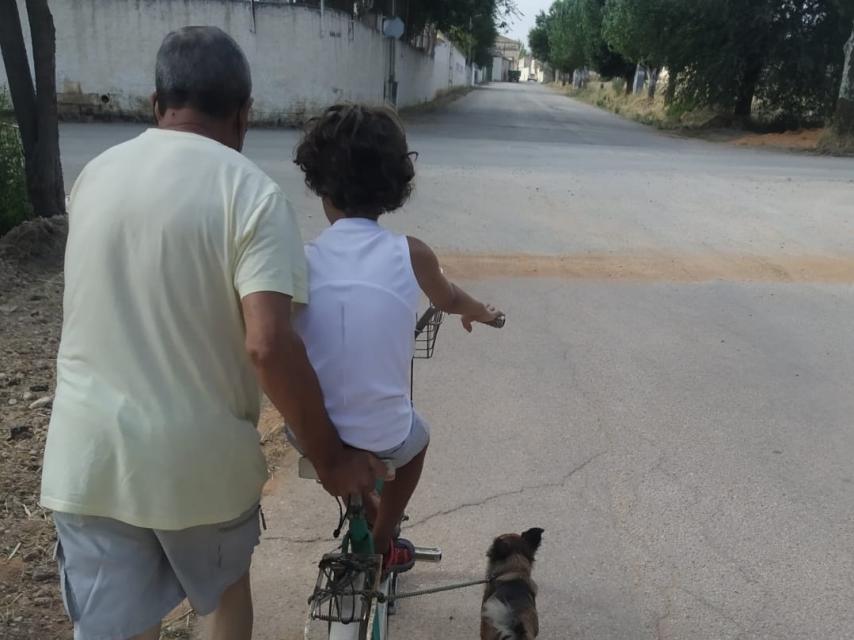 Julio paseando a su nieto con su inseparable perro.