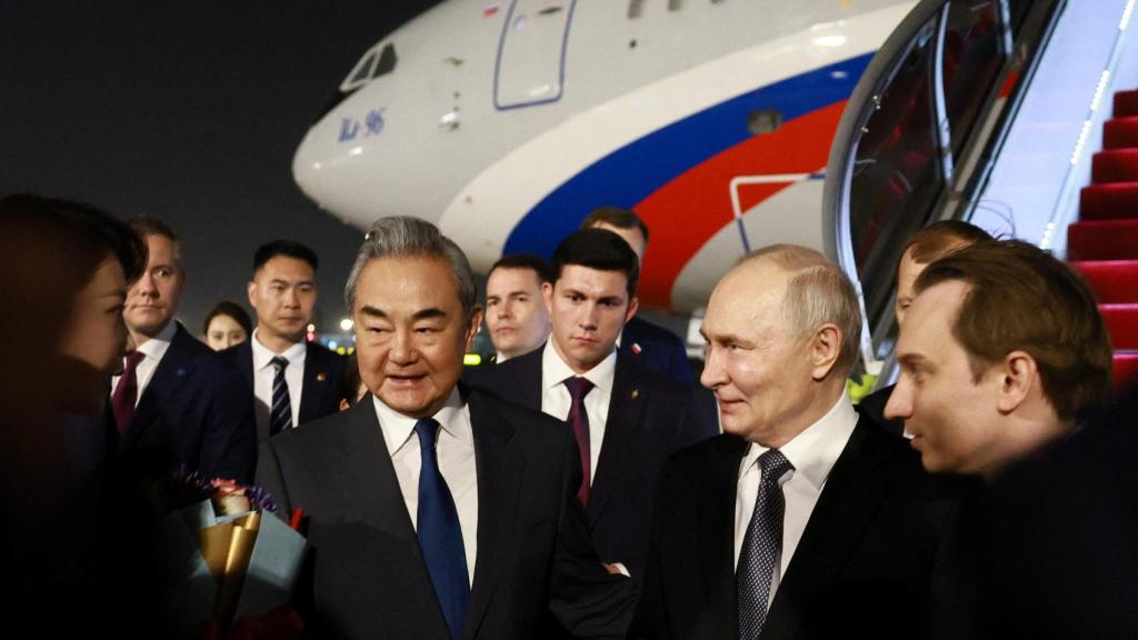 El presidente ruso Vladímir Putin, junto al ministro de Asuntos Exteriores de China, Wang Yi, durante una ceremonia de bienvenida a su llegada a un aeropuerto de Pekín.