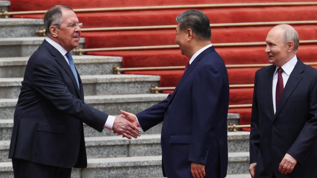 Xi Jinping saluda al ministro de Exteriores ruso, Serguéi Lavrov.