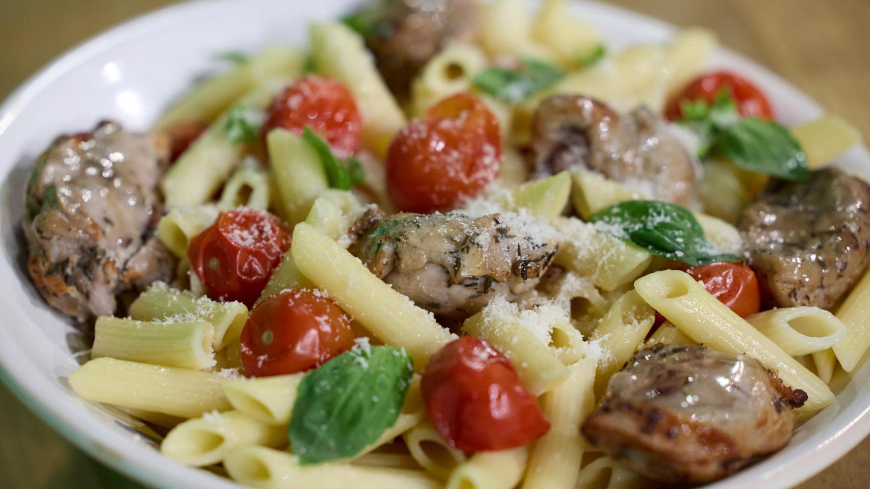 Un plato de pasta con carne de conejo. 