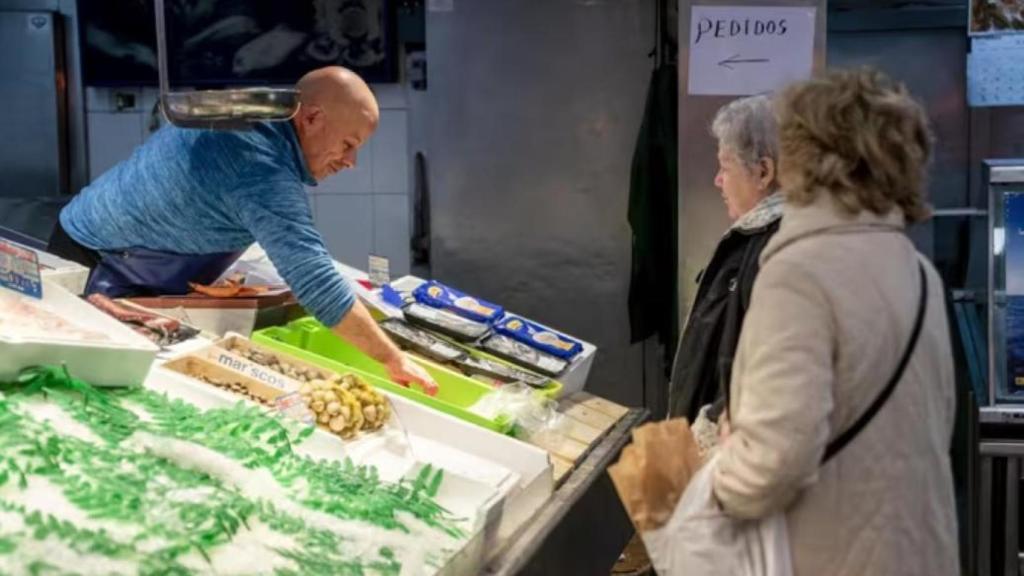 Archivo - Un trabajador autónomo atendiendo a dos clientas en su pescadería - A. Pérez Meca - Europa Press - Archivo