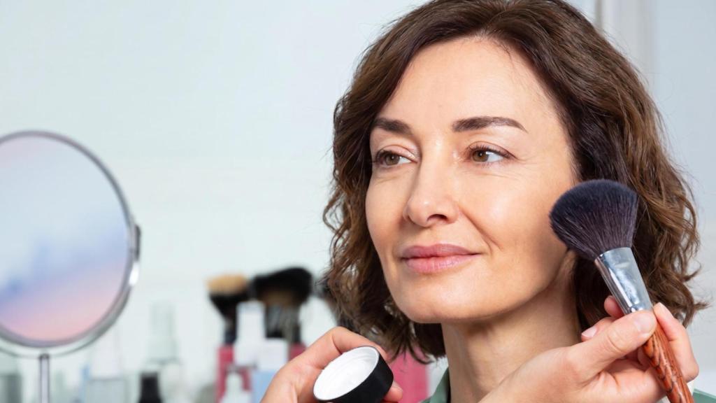 Mujer siendo maquillada por un profesional.