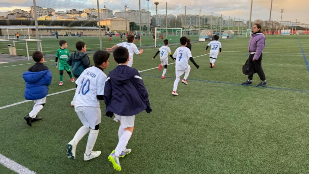 Gabriela Vázquez, con los niños del Silva que entrena antes de un partido en los campos de A Torre.