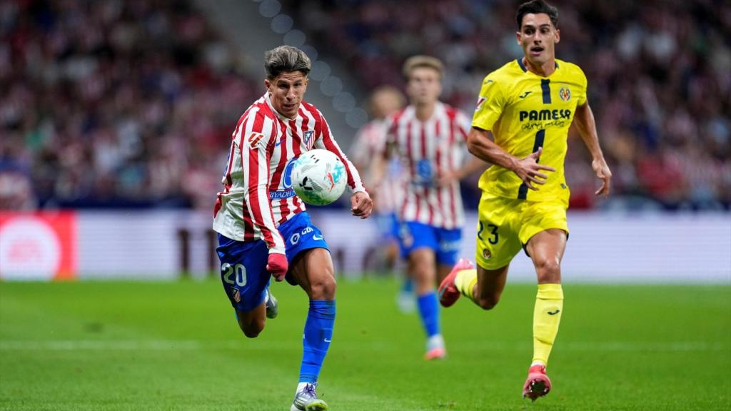 Giuliano Simeone corre a por el balón ante la presión de Sergi Cardona.