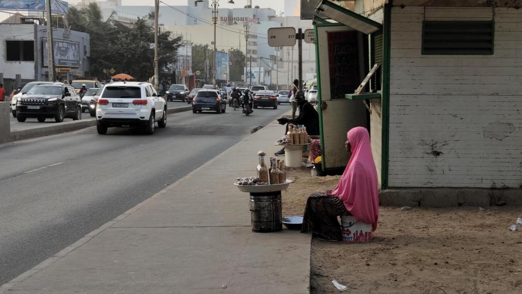 Senegalesa vendiendo maní en un puesto gallejero.