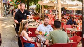 Camarero sirviendo bebidas en una terraza