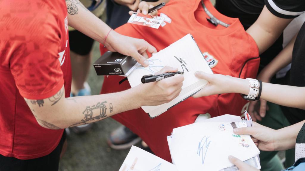 Sergio Camello firmando autógrafos a un grupo de niños de la ciudad deportiva del Rayo.