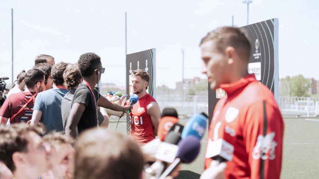 Iván Balliu y Jorge de Frutos, al frente, tratan con periodistas durante el Media Day del Rayo Vallecano.
