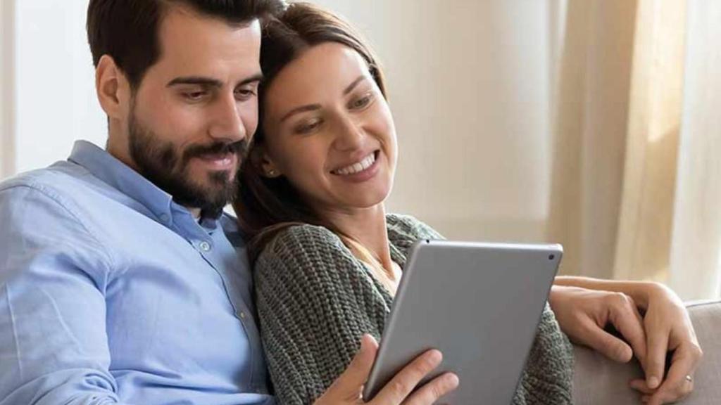 Pareja mirando una tablet.