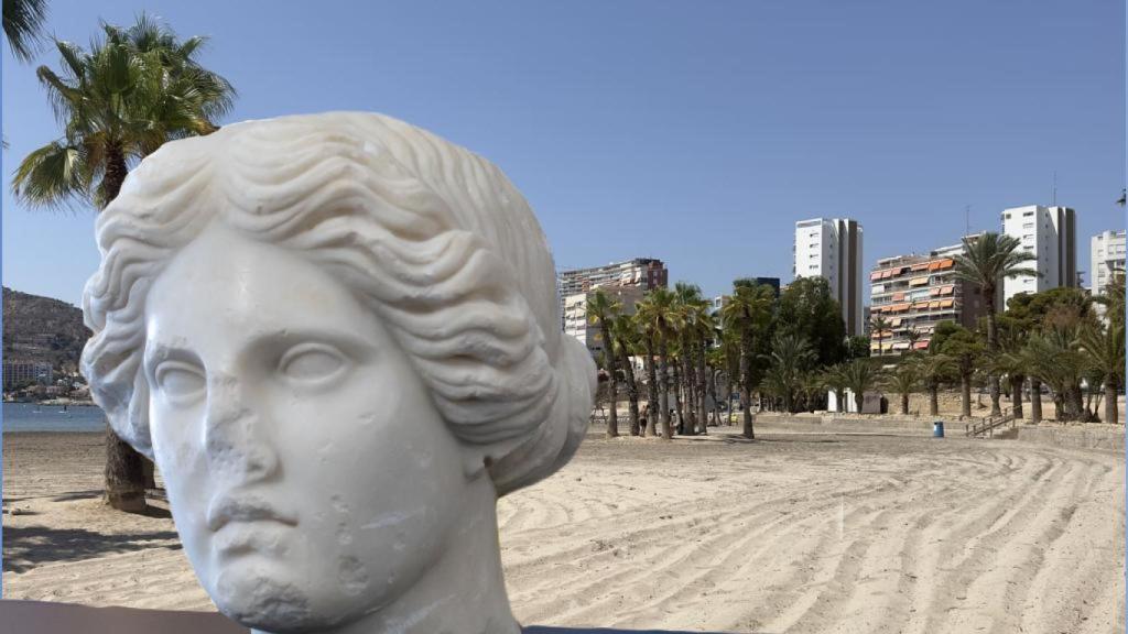 La 'Venus de Alicante' sobre una imagen de la playa de la Almadraba de Alicante.