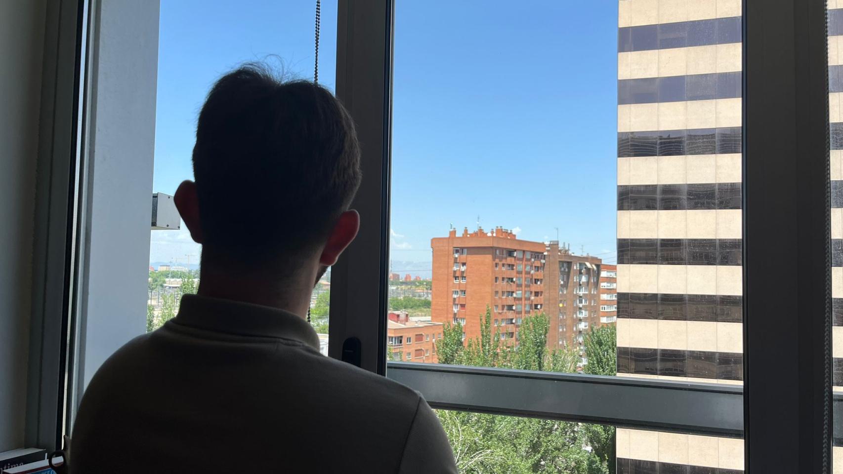 Joven observando por la ventana. 