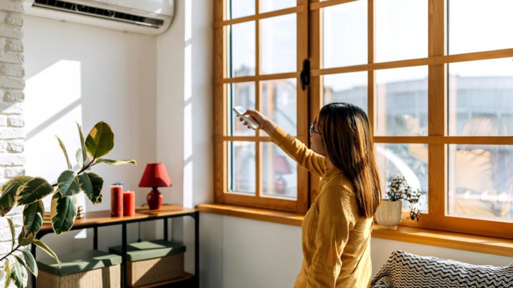 Mujer encendiendo el aire acondicionado.