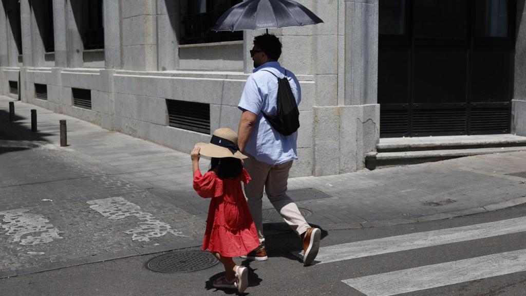 Dos personas se refugian de la ola de calor.