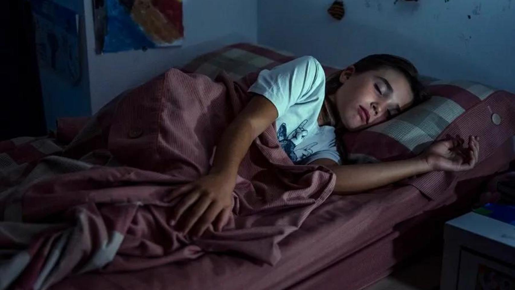 Imagen de archivo de un menor durmiendo en la cama. 