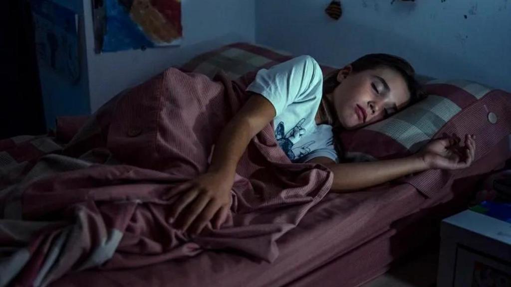 Imagen de archivo de un menor durmiendo en la cama. 