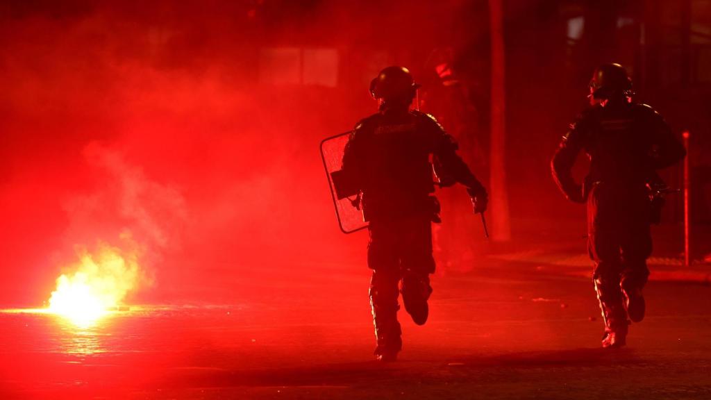 Dos policías durante los altercados en París durante las celebraciones de la victoria del PSG en la Liga de Campeones.