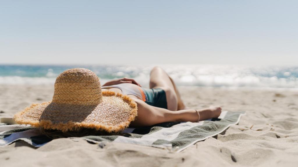Una mujer toma el sol en la playa.