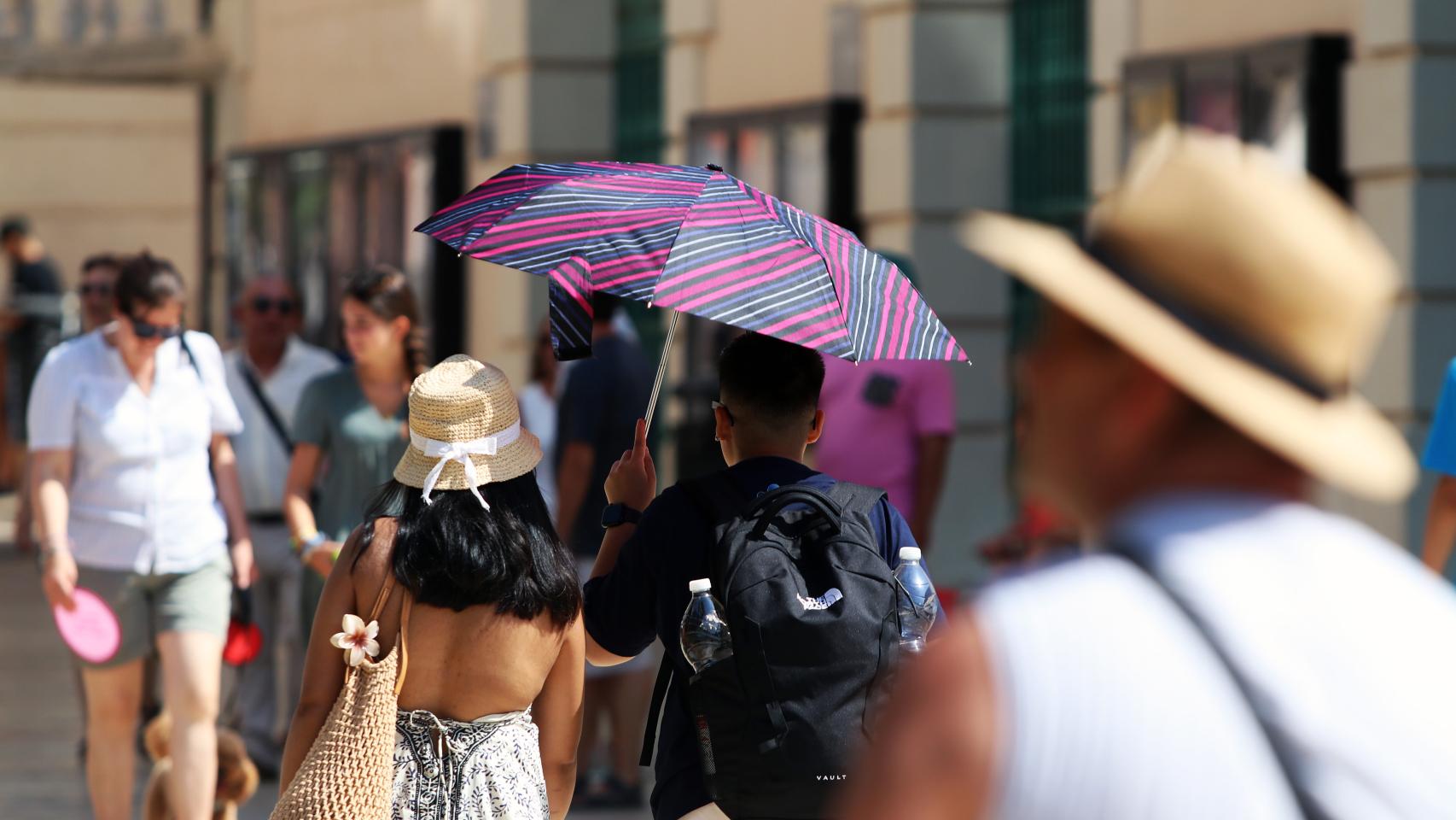 Imagen de archivo de dos personas soportando las altas temperaturas por las calles de Málaga.