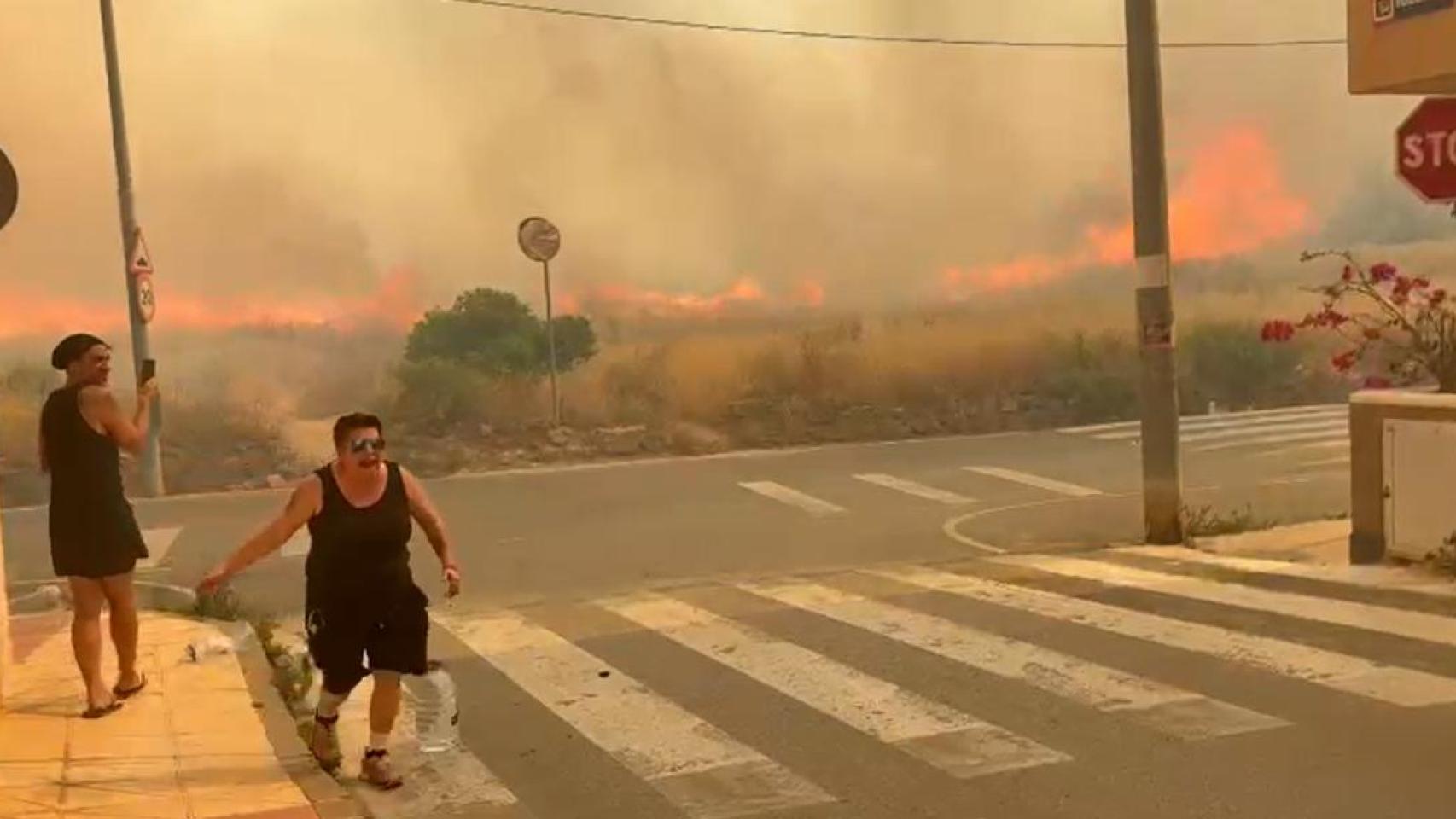 Unos vecinos de Los Garres con garrafas de agua para combatir el incendio declarado este martes.