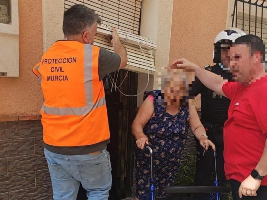 Una anciana que precisa de un andador, este martes, siendo evacuada de su casa por el incendio de Los Garres.