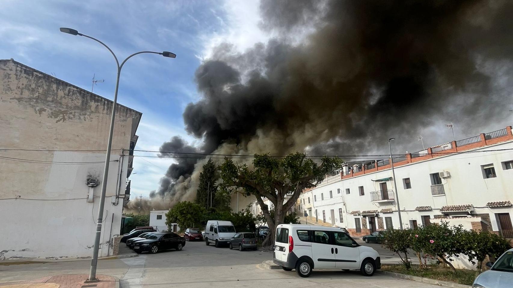 La columna de humo del incendio del taller de camiones en Vélez-Málaga.