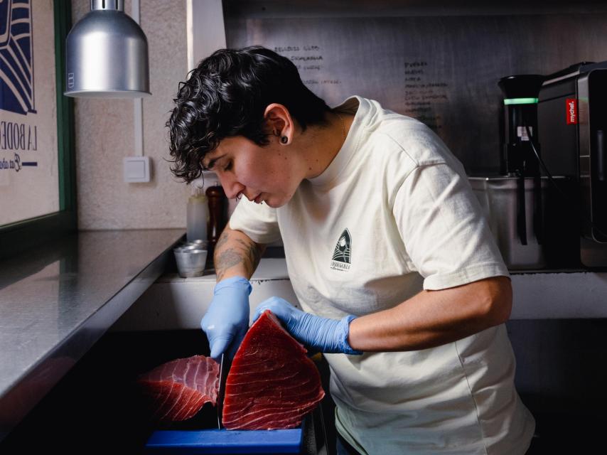 Jessica cortando una pieza de atún en la estrecha cocina de La Bodeguilla.