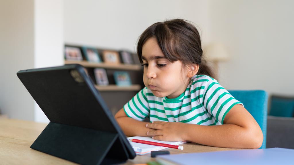 Una niña haciendo los deberes en una tablet.
