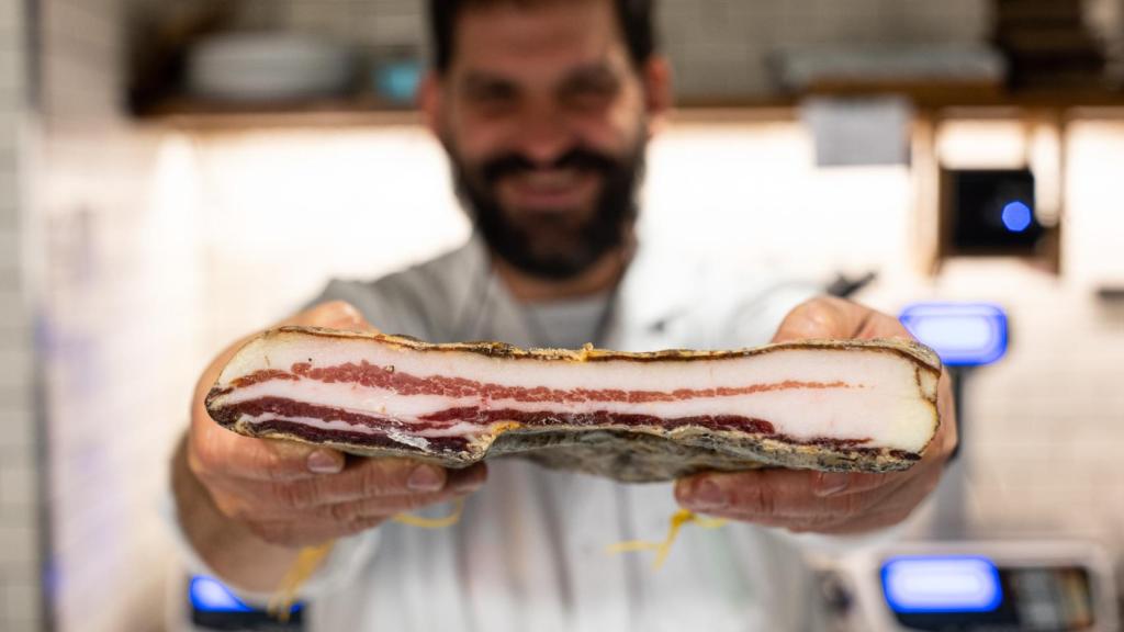 César Wilson Sagrario con un lingote de panceta curada.
