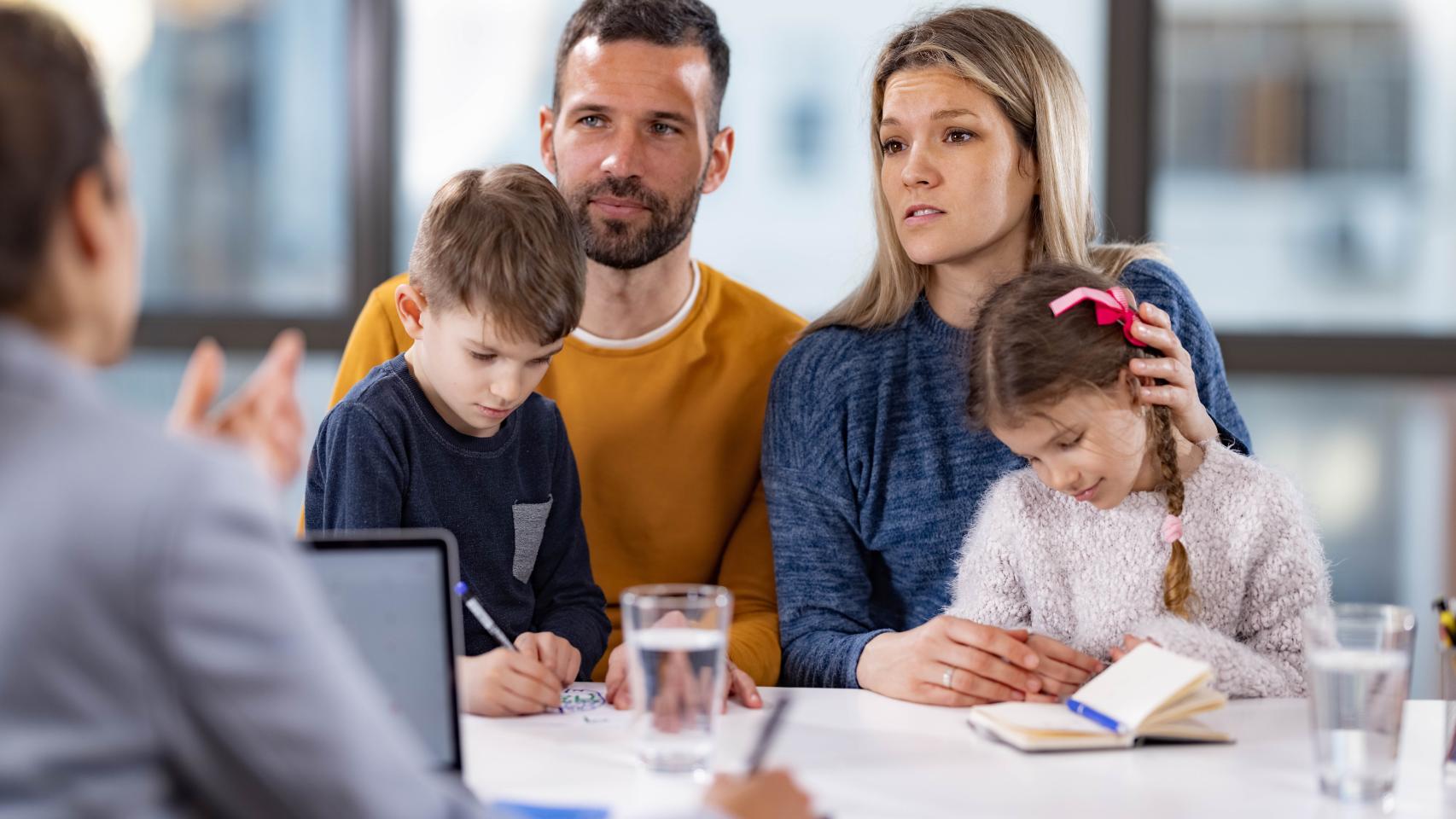 Unos padres con sus hijos ante el notario. 