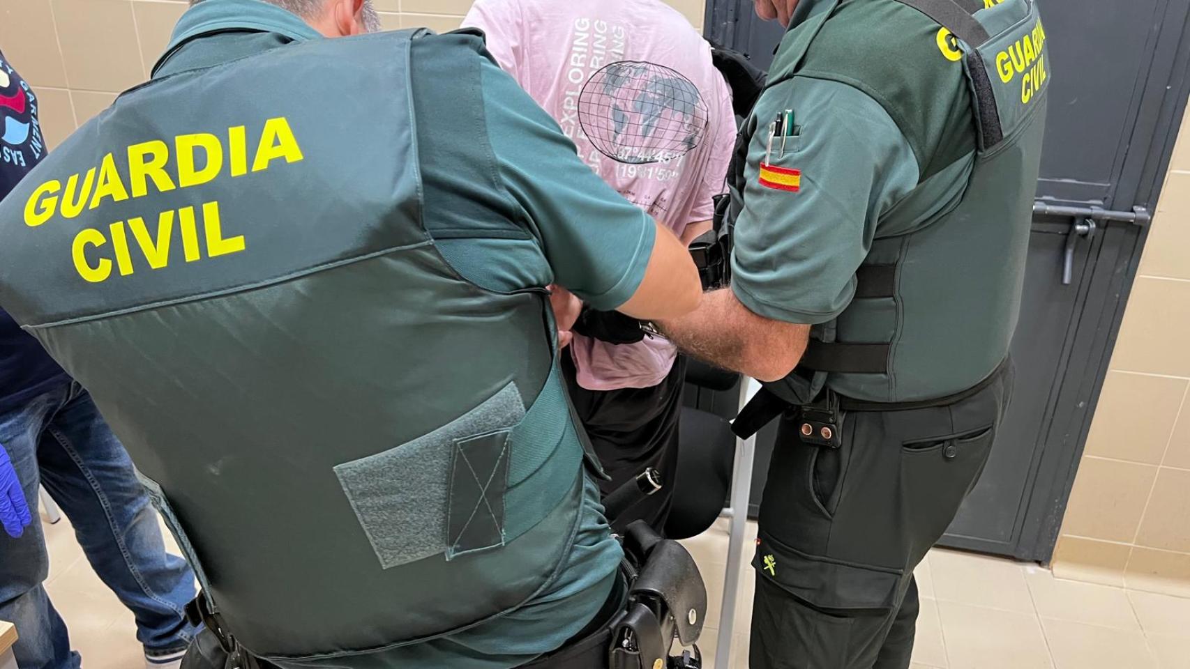 Dos agentes de la Guardia Civil, con el presunto autor del crimen. 