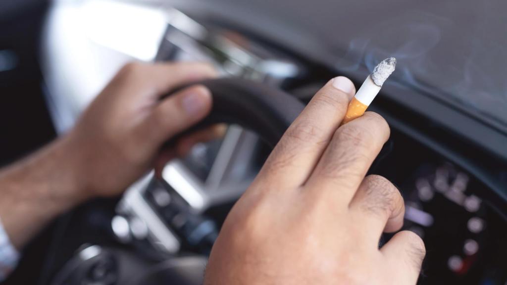 Un conductor sostiene un cigarrito